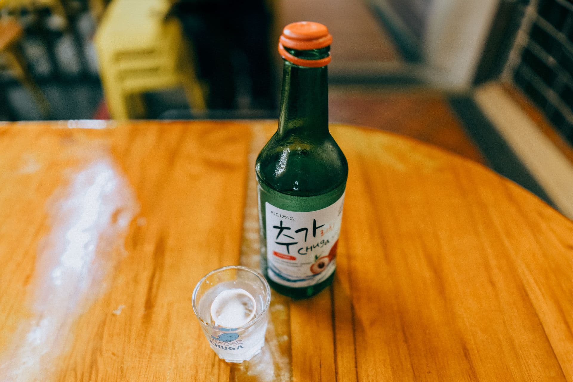 Soju etiquette — pouring a shot glass with two hands, Korean drinking culture at the table