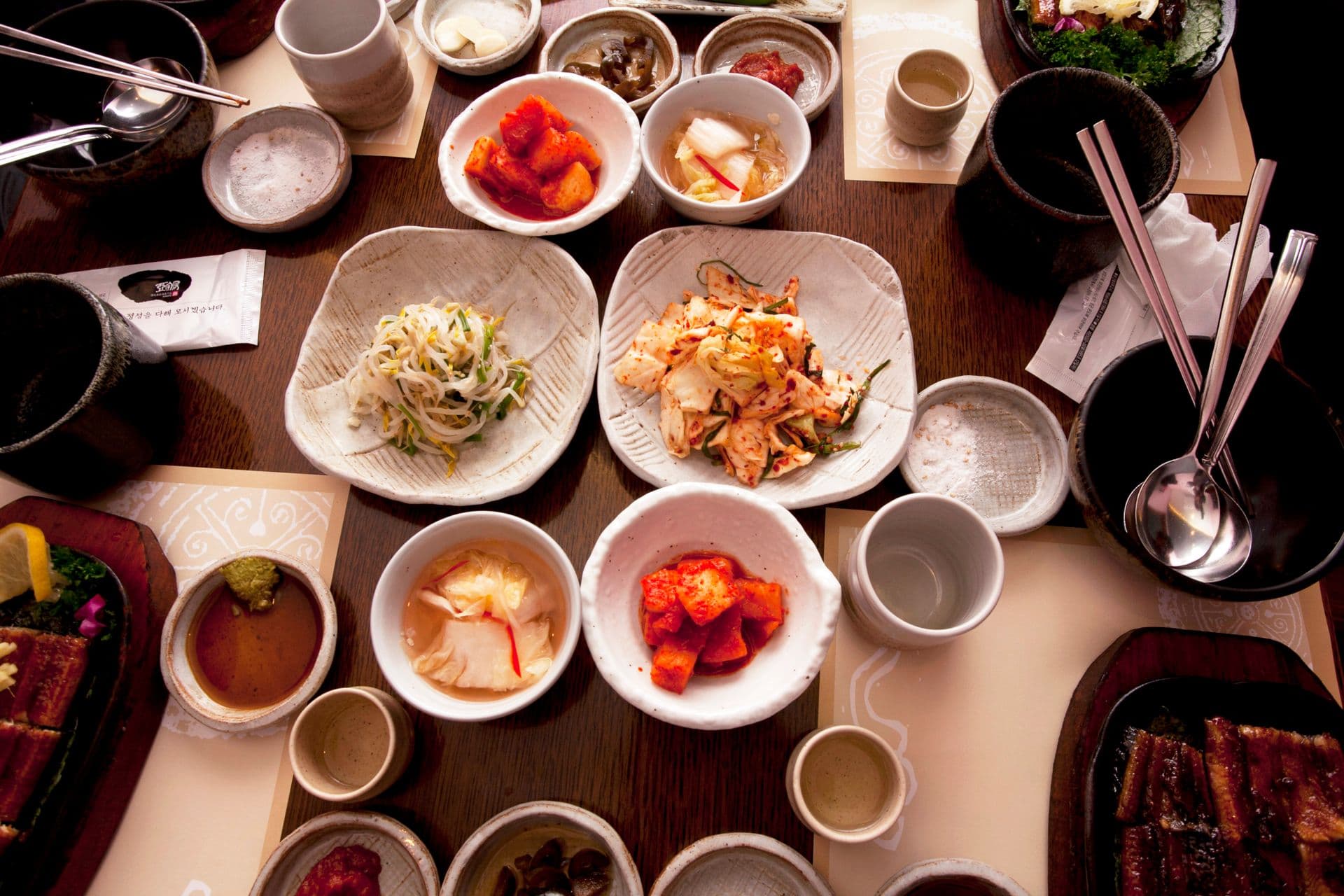 What is banchan — Korean table covered in small side dish plates around rice and stew