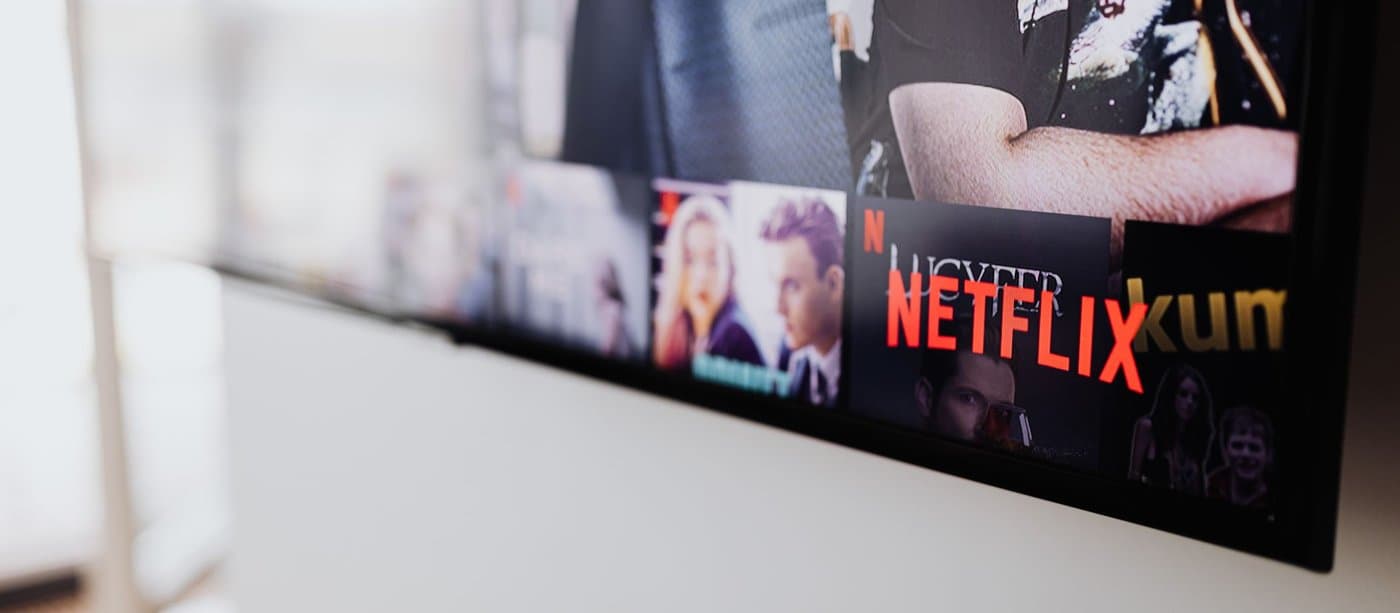 Streaming catalogue rows glowing on a television screen, shot from an angle