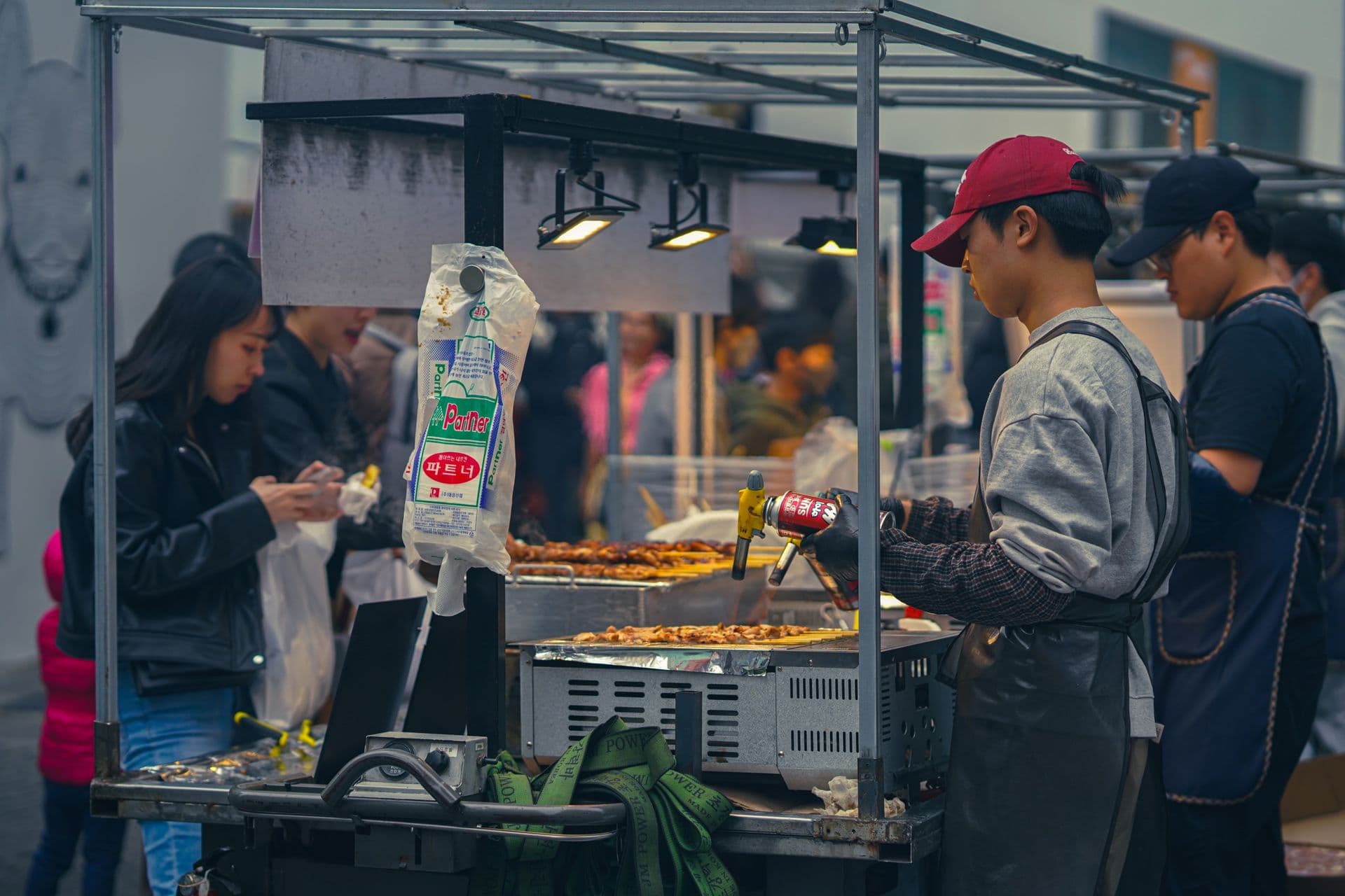 Korean street food stall in Seoul — tteokbokki, odeng skewers and hotteok on a night market cart